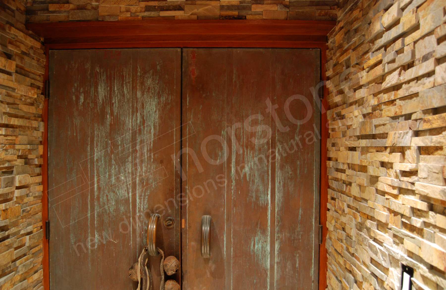 Norstone Ochre Stacked Stone Rock Panels on Entrway to underground Wine Cellar in California with metal rusted doors